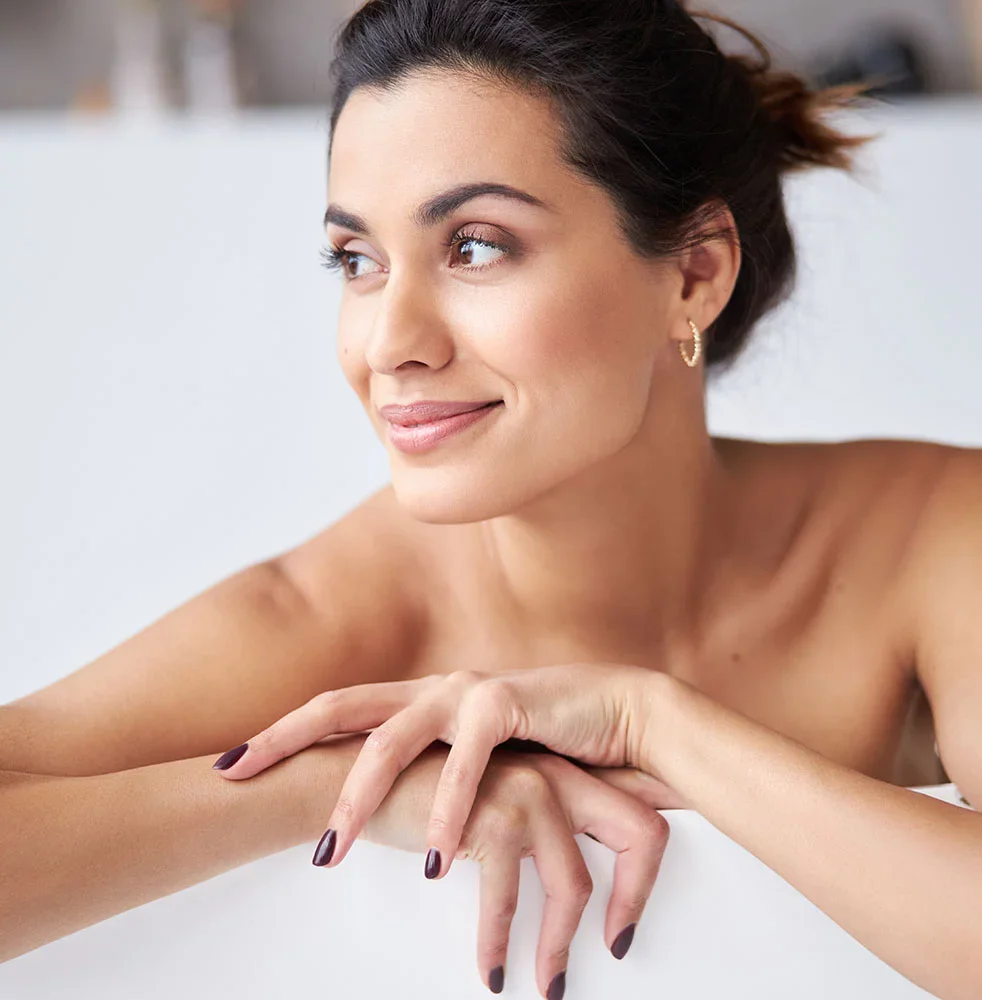 Woman with dark hair sitting on the edge of her tub | Brow Lifts in Orlando
